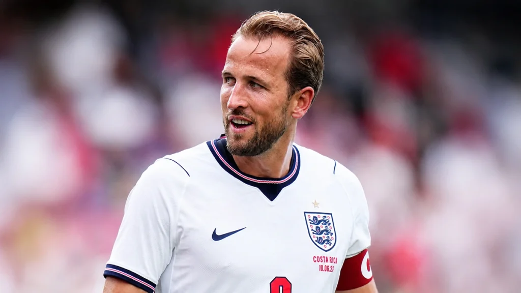 Harry Kane smiling during a football match in an England shirt