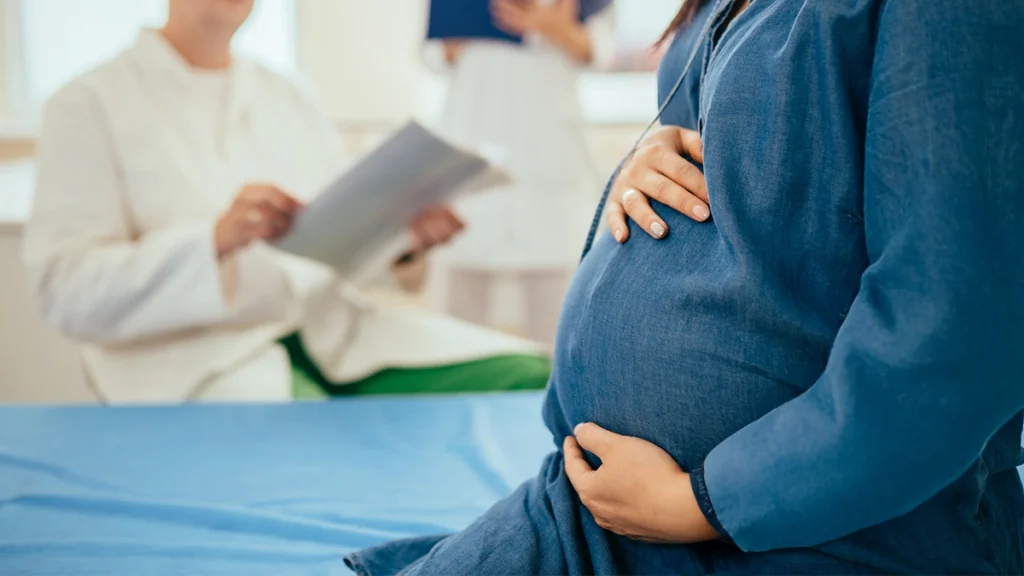 Pregnant patient discussing dental implant planning with doctor