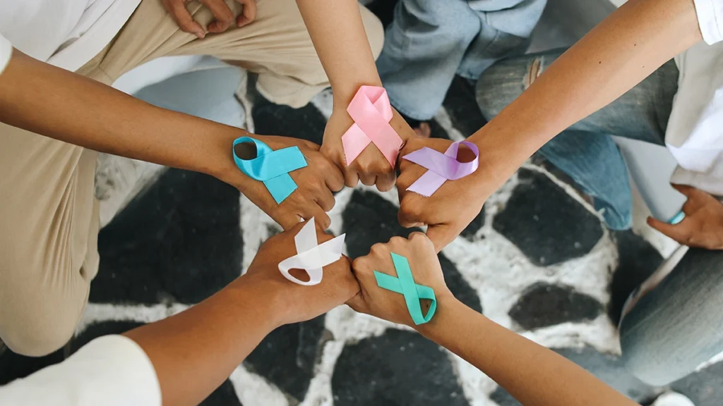 Cancer patients holding colorful cancer awareness ribbons together