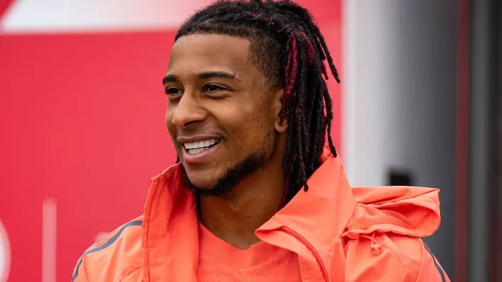 Michael Olise smiling during a relaxed football team appearance