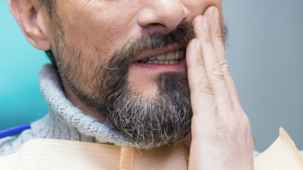 Patient experiencing TMJ pain after dental implant surgery
