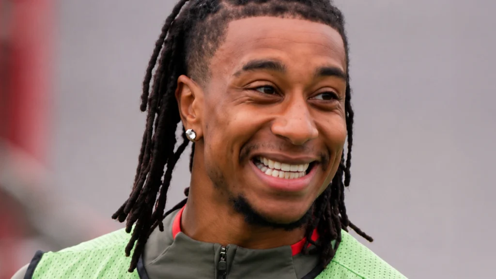 Michael Olise smiling with visible teeth during football training
