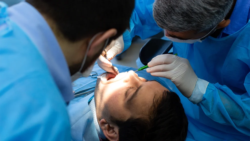 Dentists controlling bleeding during dental implant surgery