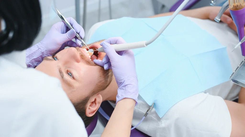 Patient receiving professional dental cleaning as part of teeth whitening maintenance