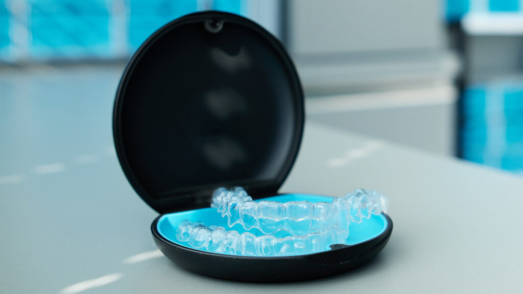 Custom sports mouthguard displayed in a protective case for preventing dental injuries during football games.