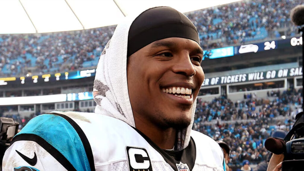 NFL quarterback smiling on the field after a game, highlighting oral health and confidence in professional football.