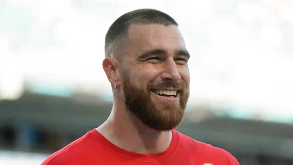 Smiling NFL player in a red shirt, illustrating the importance of preventive dental care and healthy oral habits for athletes.