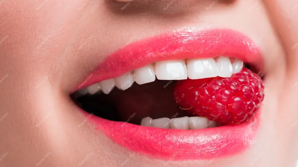Close-up of a woman biting a raspberry, illustrating chewing comfort and function when comparing snap-on dentures vs All-on-4.