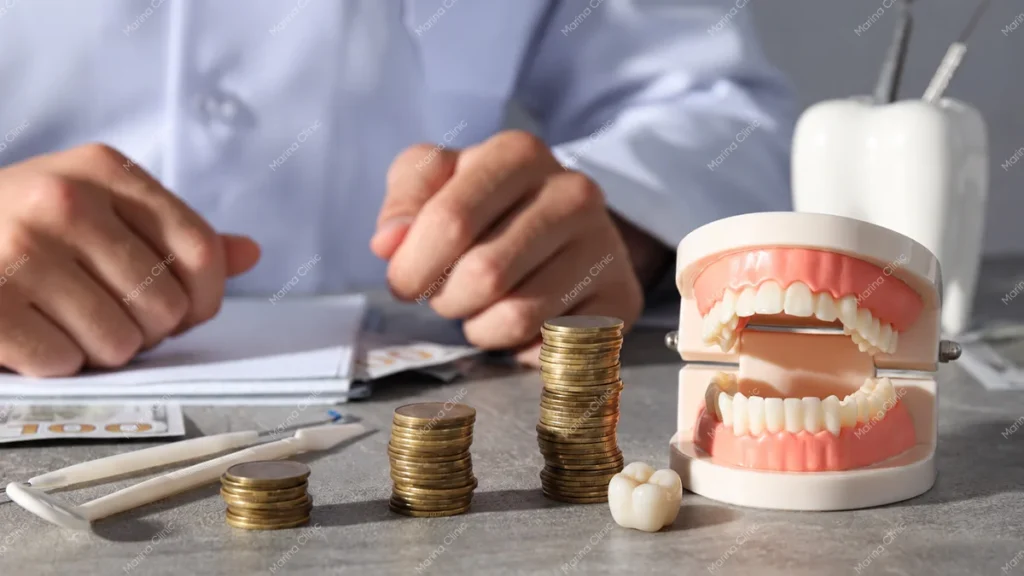 Dental bonding cost vs dental crown cost comparison with stacked coins, a dental model, and treatment planning documents.